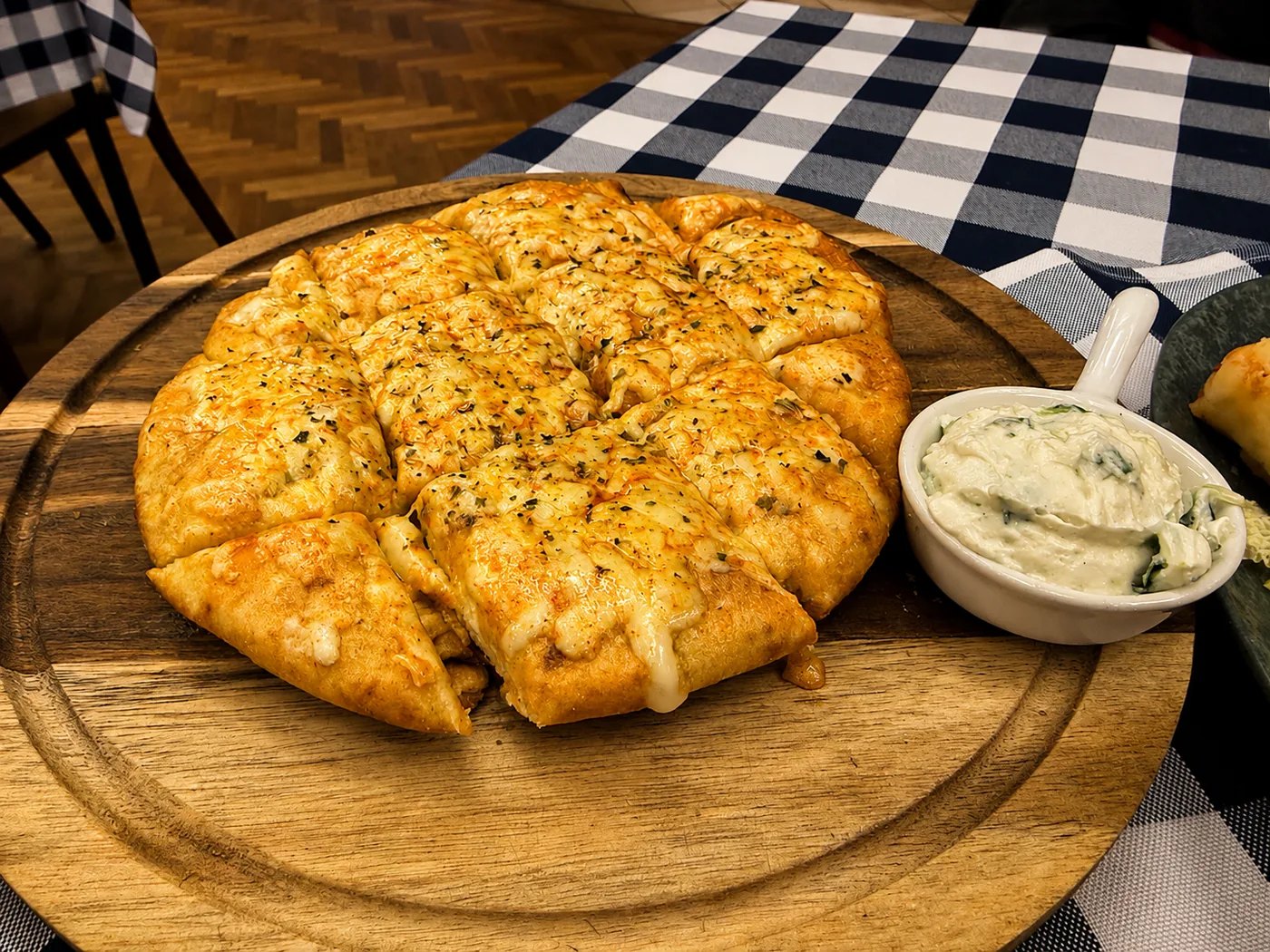 Pita vom Holzbrett: Warm serviertes Pita-Brot mit cremigem Dip – schlicht, knusprig und gesellig.